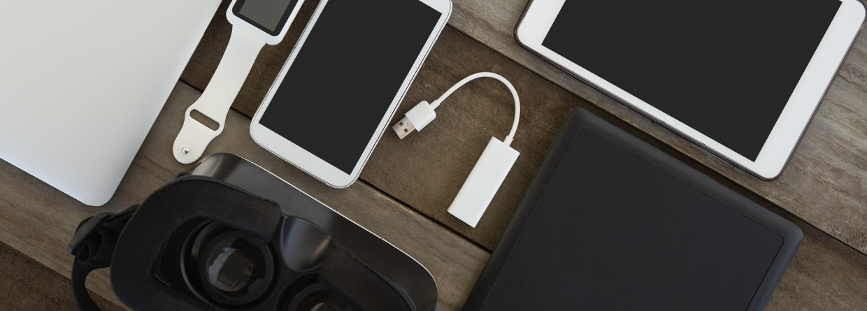 Verschillende electronische apparaten op een houten tafel