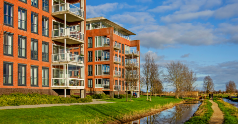 Appartementcomplexen in Pijnacker met gras voor de deur, een wandelpad en sloot