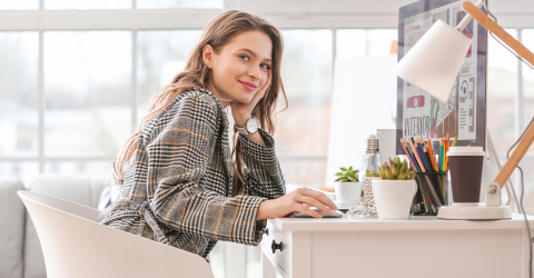 Vrouwelijke ondernemer aan het werk achter haar bureau en computer